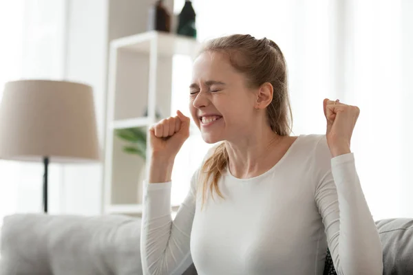 Mulher feliz sentada no sofá celebrar boas notícias — Fotografia de Stock