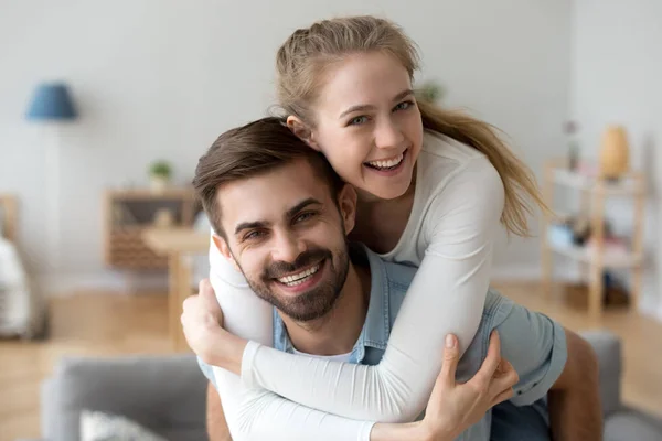 Par embracing på hem tittar på kameran — Stockfoto