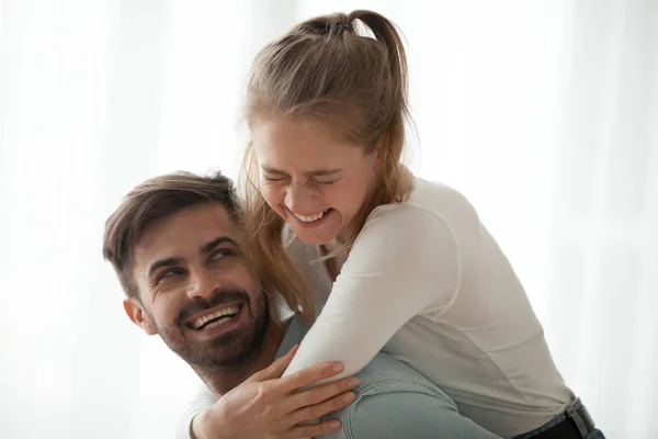 Молодая пара обнимается дома и смеется — стоковое фото