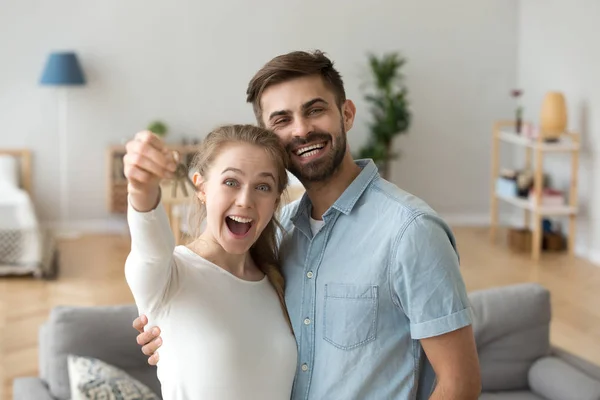 Pareja enamorada de pie en la sala de estar en la nueva casa — Foto de Stock