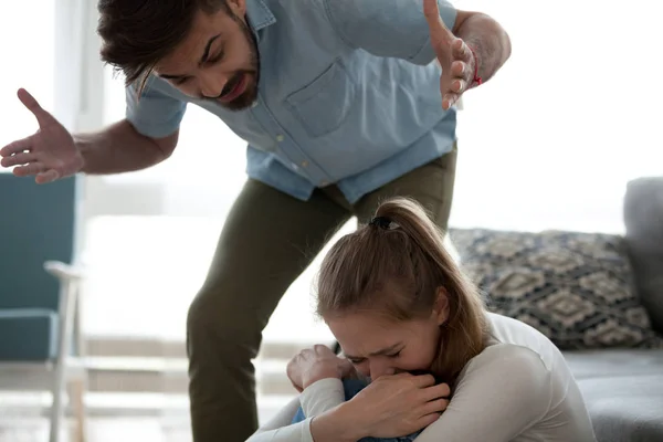 Angry man and frightened woman at home