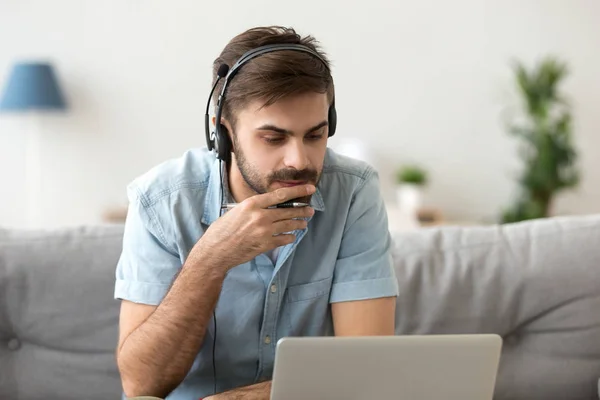 Man studying using computer and headset online — Stock Photo, Image