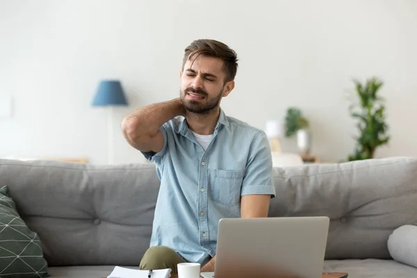 Man having neck pain sitting working at home