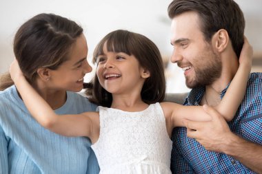 Portre mutlu çekici genç aile kucaklayan poz 