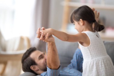 Baba ve kızı birlikte el ele tutuşarak koltukta yalan oynamak