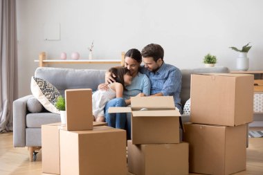 Yeni evde hissediyor mutlu sarılma kanepede oturan aile