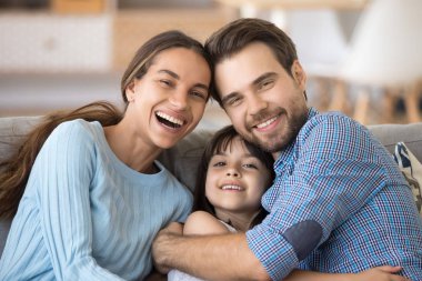 Mutlu neşeli aile evde kanepede oturan kucaklayan
