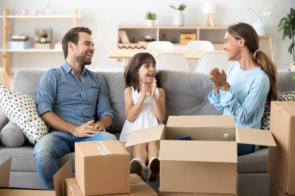 Glückliche Familie sitzt auf der Couch im neuen Zuhause — Stockfoto