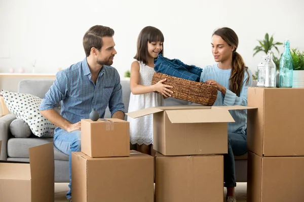 Multi-ethnische Familie packt Habseligkeiten aus, die im neuen Hom im Zimmer sitzen — Stockfoto