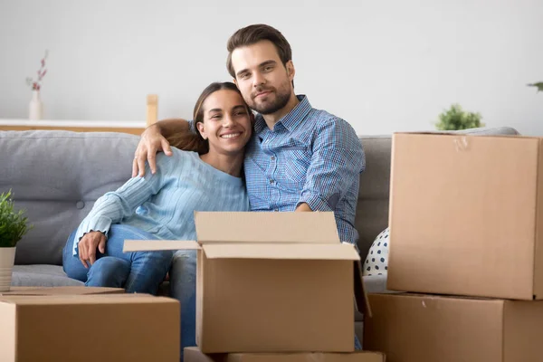 Hermosa familia sentada en el sofá en el nuevo hogar — Foto de Stock