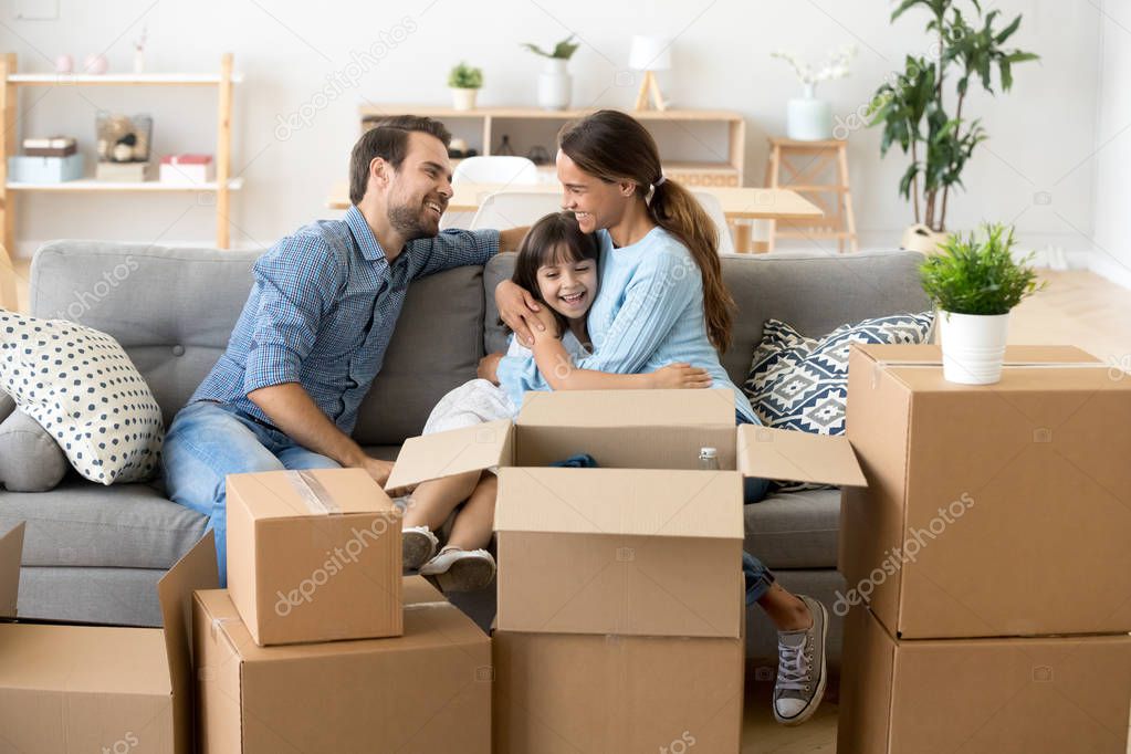 Attractive family sitting in living room at new dwelling