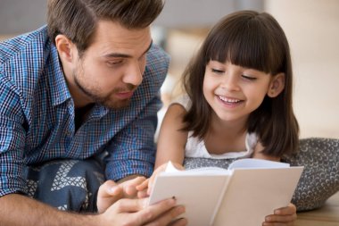 Baba ve çocuk bir kitap okuma sıcak yerde yatarken