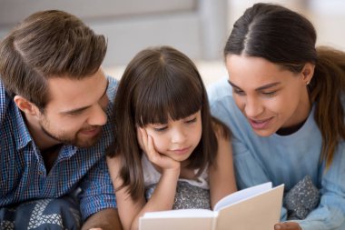 Çeşitli ailesi bir kitap okuma sıcak yerde yatarken
