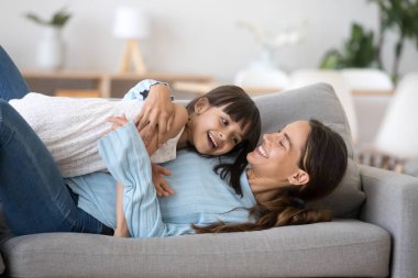 Yan yana evde kanepede yatarken anne kucaklama kızı