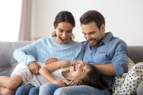 Baba ve kızı yalan kanepe gıdıklıyor üzerinde oturan anne