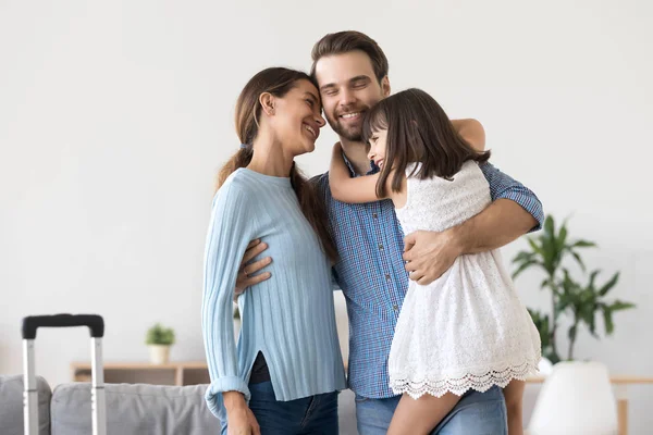 Happy family embracing standing in living room — Stock Photo, Image