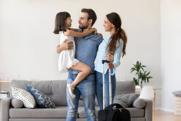 Diverse family standing in living room with suitcase luggage