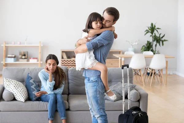 Unhappy married couple and daughter in living room