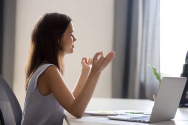 Bin yıllık kız rahatlatıcı medi üzerinde odaklanan dizüstü bilgisayar ile yoga yaparken