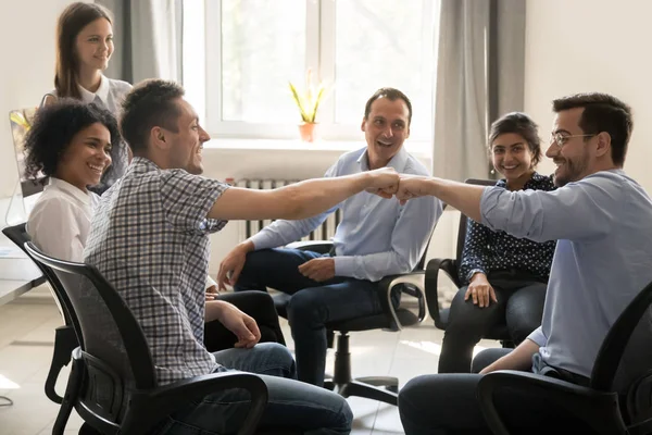 Männliche Kollegen schlagen bei Gruppentreffen mit der Faust zu — Stockfoto