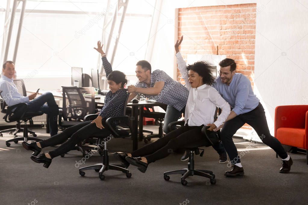 Carefree excited diverse office workers having fun riding oh cha