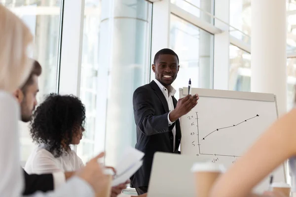 Smiling African American coach give flipchart presentation to em — Stock Photo, Image