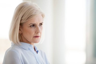 Mesafe durulması içinde düşünceli orta yaşlı işkadını bak
