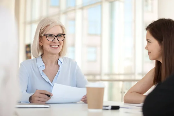 Smiling female businesswoman hold meeting with colleagues in off — Stock Photo, Image