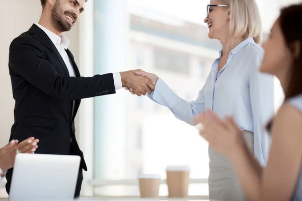 Excited business partners handshake after successful meeting