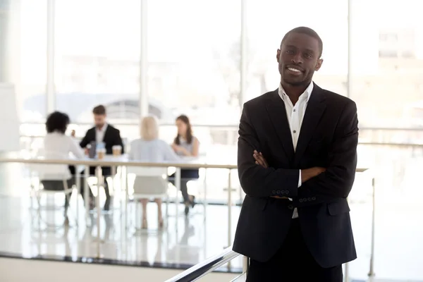 Portret uśmiechający się biznesmen czarny stojący pozowanie w biurze — Zdjęcie stockowe