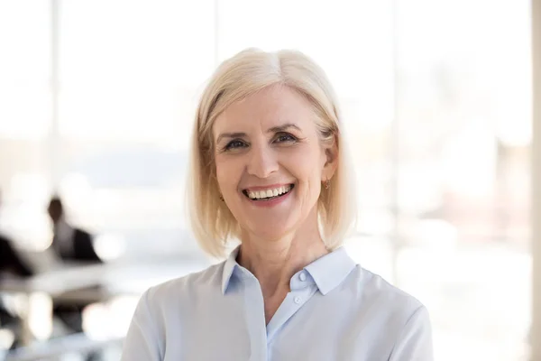 Retrato de mujer de negocios madura posando sonriendo a la cámara — Foto de Stock