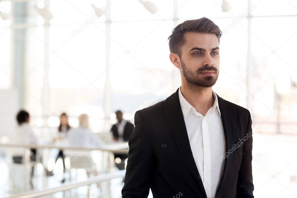Focused millennial businessman look in distance dreaming of busi