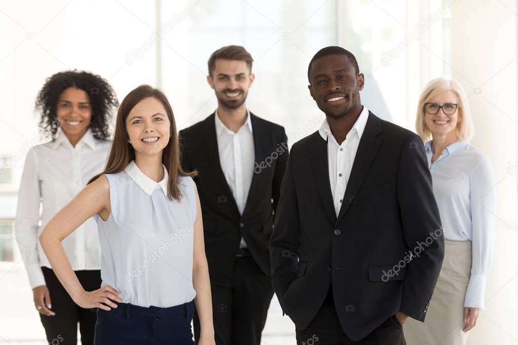 Portrait of smiling diverse work team standing posing in office