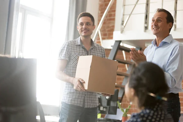 Team leader introducing new employee holding box on first day — Stock Photo, Image