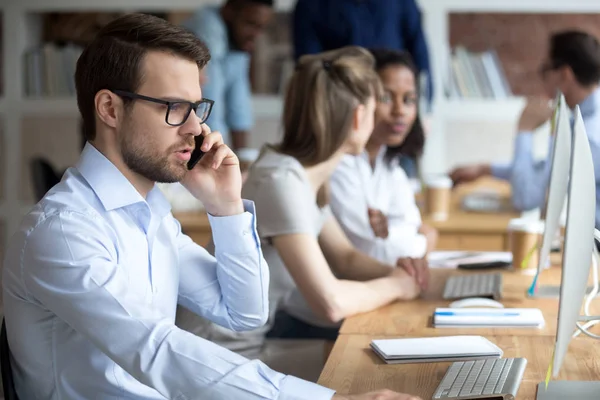 Hablar serio empleado masculino en el teléfono de trabajo en el ordenador — Foto de Stock