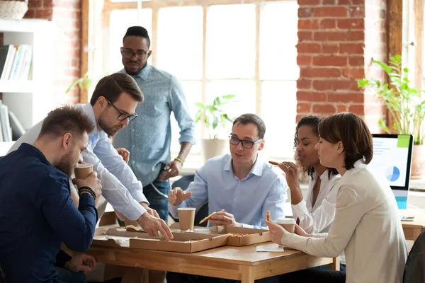 Diverse colleagues enjoy pizza having lunch break in office — Stock Photo, Image