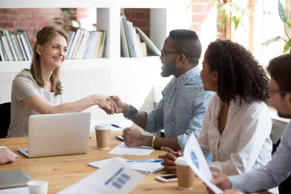 Millennial empresaria apretón de manos negro empleado saludo a mí —  Fotos de Stock