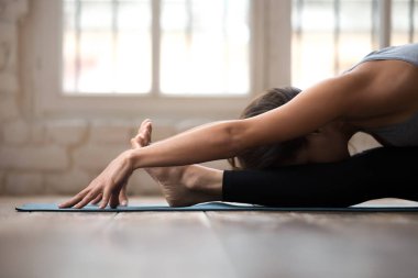 Pratik yoga, Genç sportif kadın oturmuş ileri bend