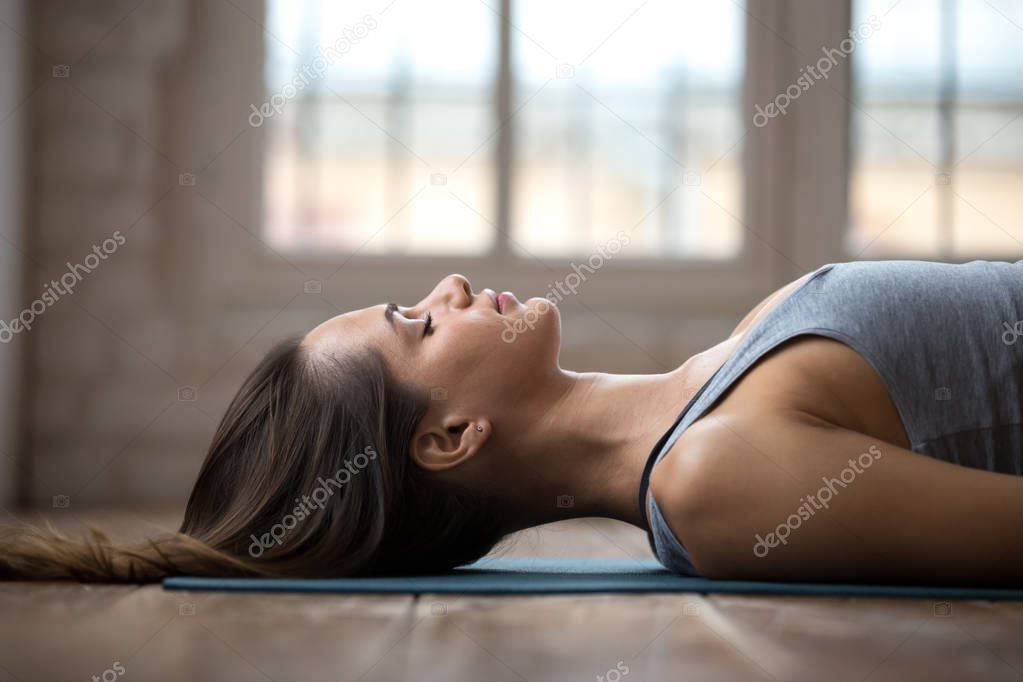 Young attractive woman practicing yoga, doing Dead Body, close u