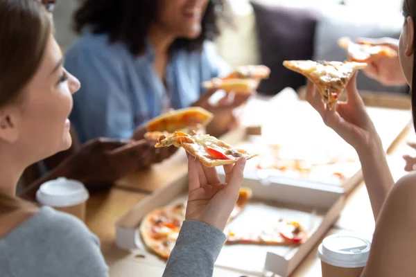 Diverse friends enjoying time together eating pizza