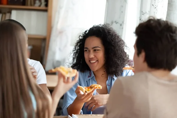 Diverse cheerful people eating pizza in pizzeria — Stock Photo, Image