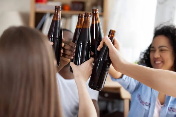 Diversos amigos tintineo botellas de vidrio con cerveza —  Fotos de Stock