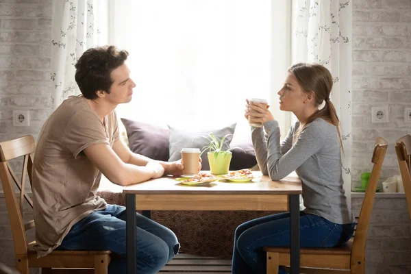 Пара, сидящая в кафе и пьющая кофе, ест пиццу — стоковое фото