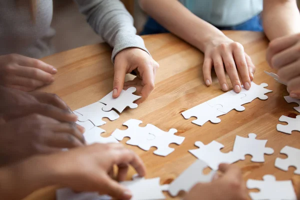 Mani di persone multirazziali assemblaggio puzzle da vicino — Foto Stock