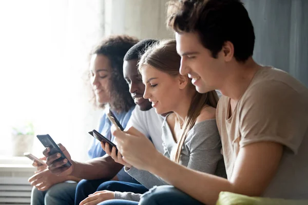Diverse people sitting together using mobile phones — Stock Photo, Image