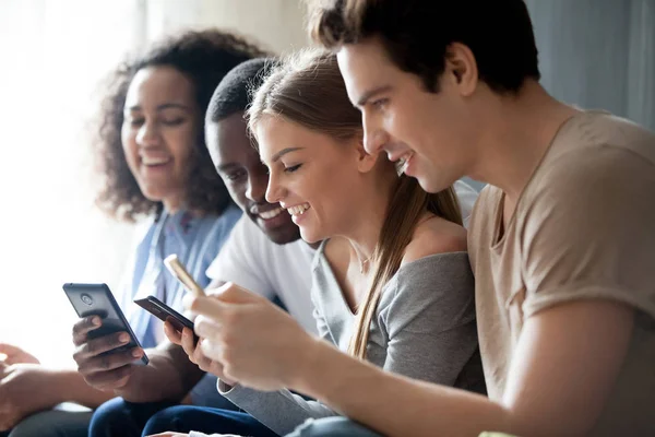 Young people sitting together indoor using gadgets — Stock Photo, Image