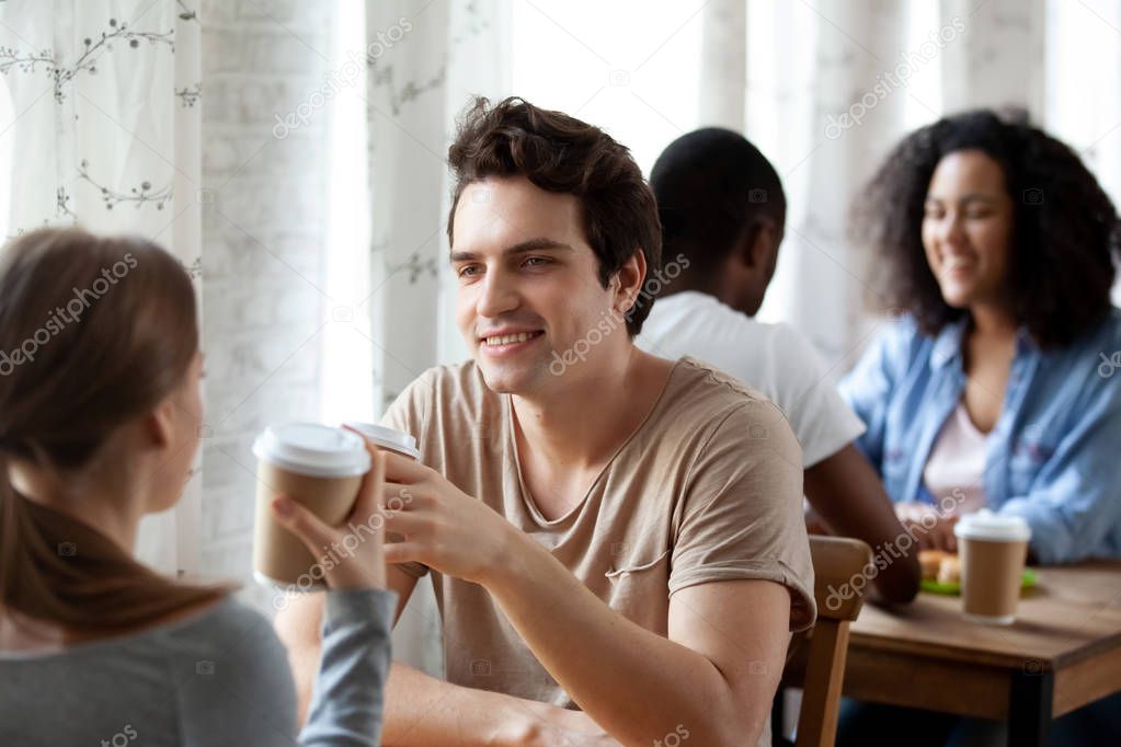 Diverse students sitting in cafe drinking hot beverages