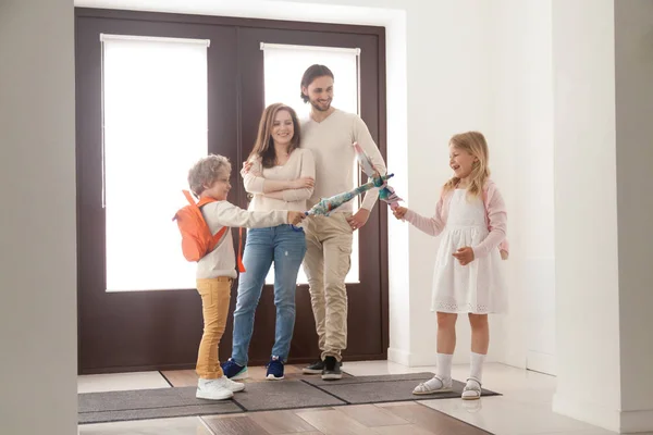 Married couple with playful children in hallway at home — Stock Photo, Image