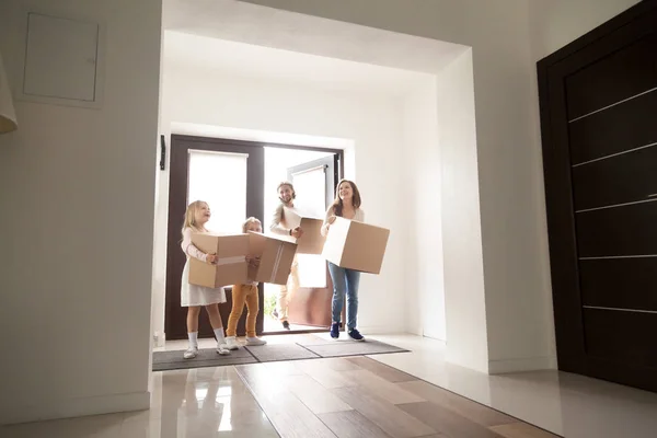 Familia feliz en el pasillo con cajas de cartón — Foto de Stock