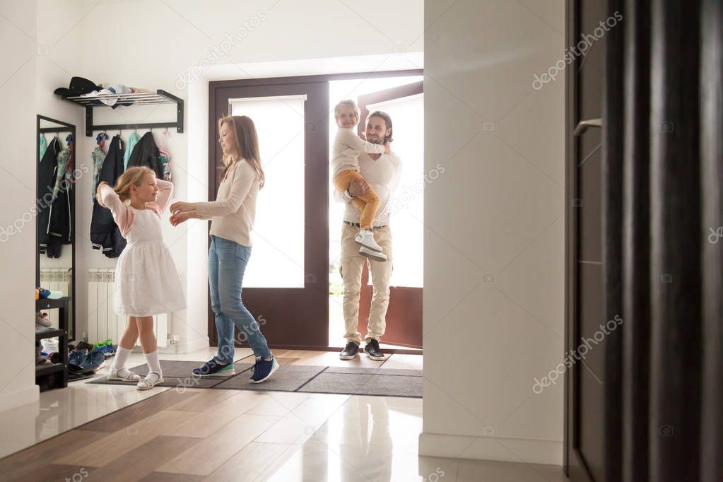 Couple with children in hallway gather for a walk